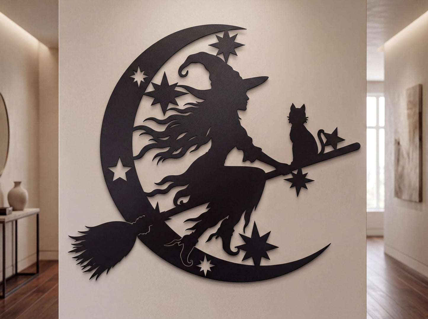 a wall decoration depicting a witch riding a broomstick with a cat on her shoulder, surrounded by stars and a crescent moon.