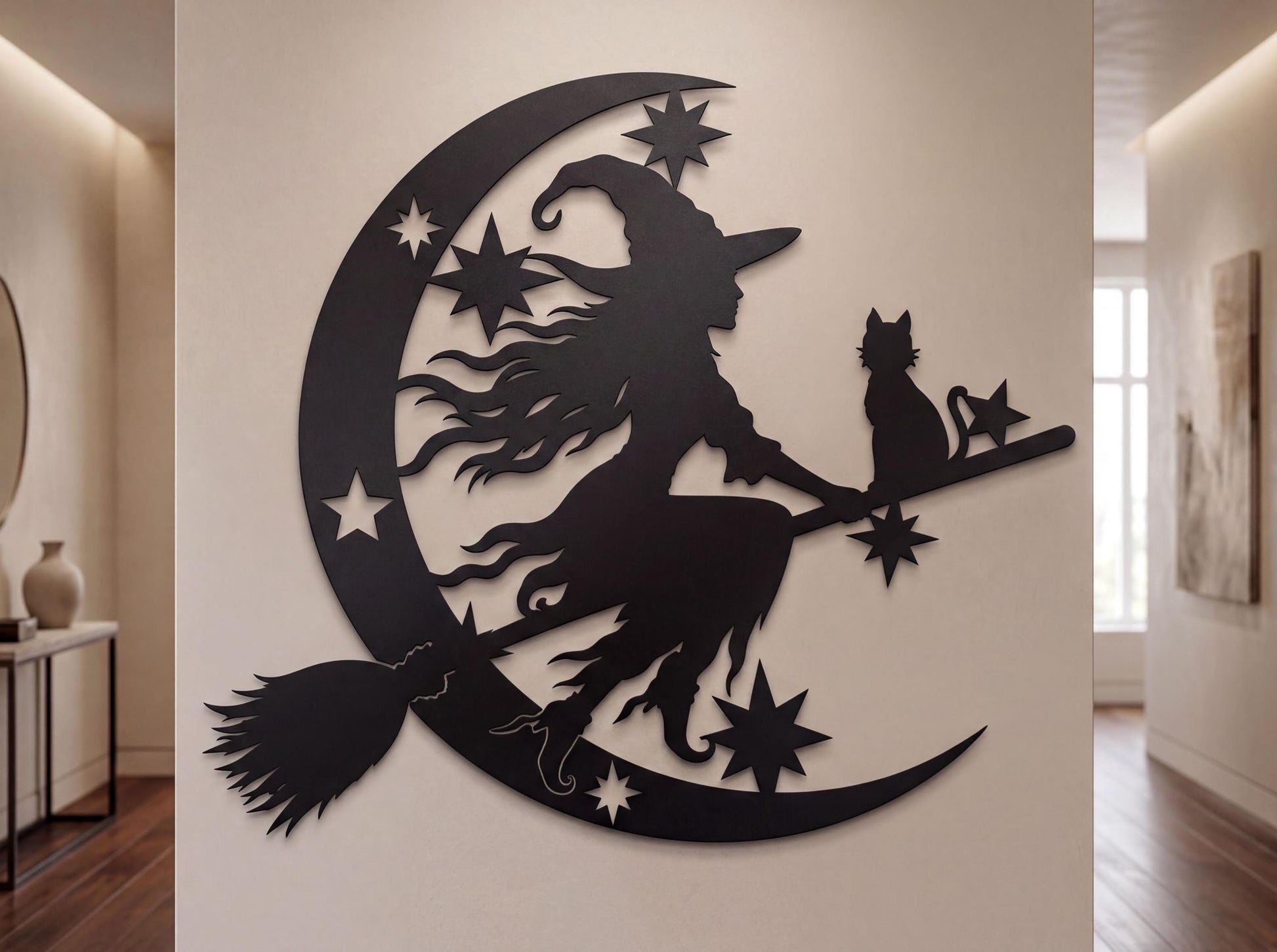 a wall decoration depicting a witch riding a broomstick with a cat on her shoulder, surrounded by stars and a crescent moon.