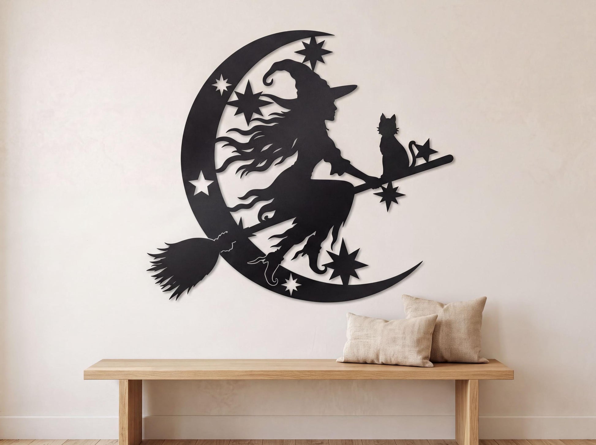 A wall decal depicting a witch riding a broomstick with a cat on a crescent moon, surrounded by stars.