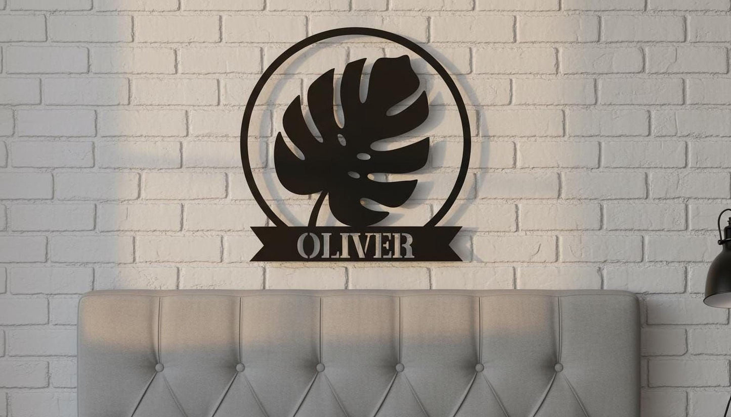 A black metal wall decoration featuring a large leaf silhouette is mounted on a white brick wall above a tufted gray headboard.