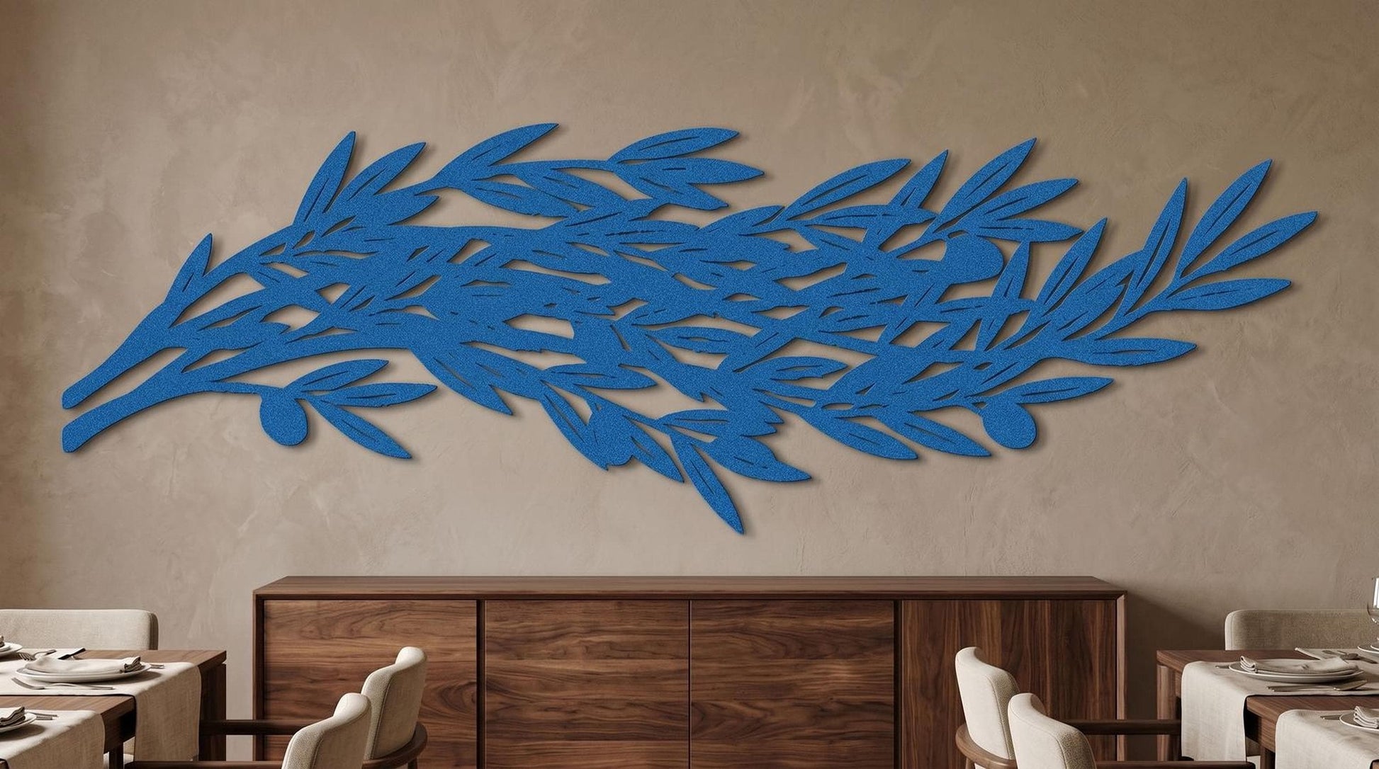 a large blue leaf-shaped wall art piece hanging on a beige wall above a wooden cabinet.