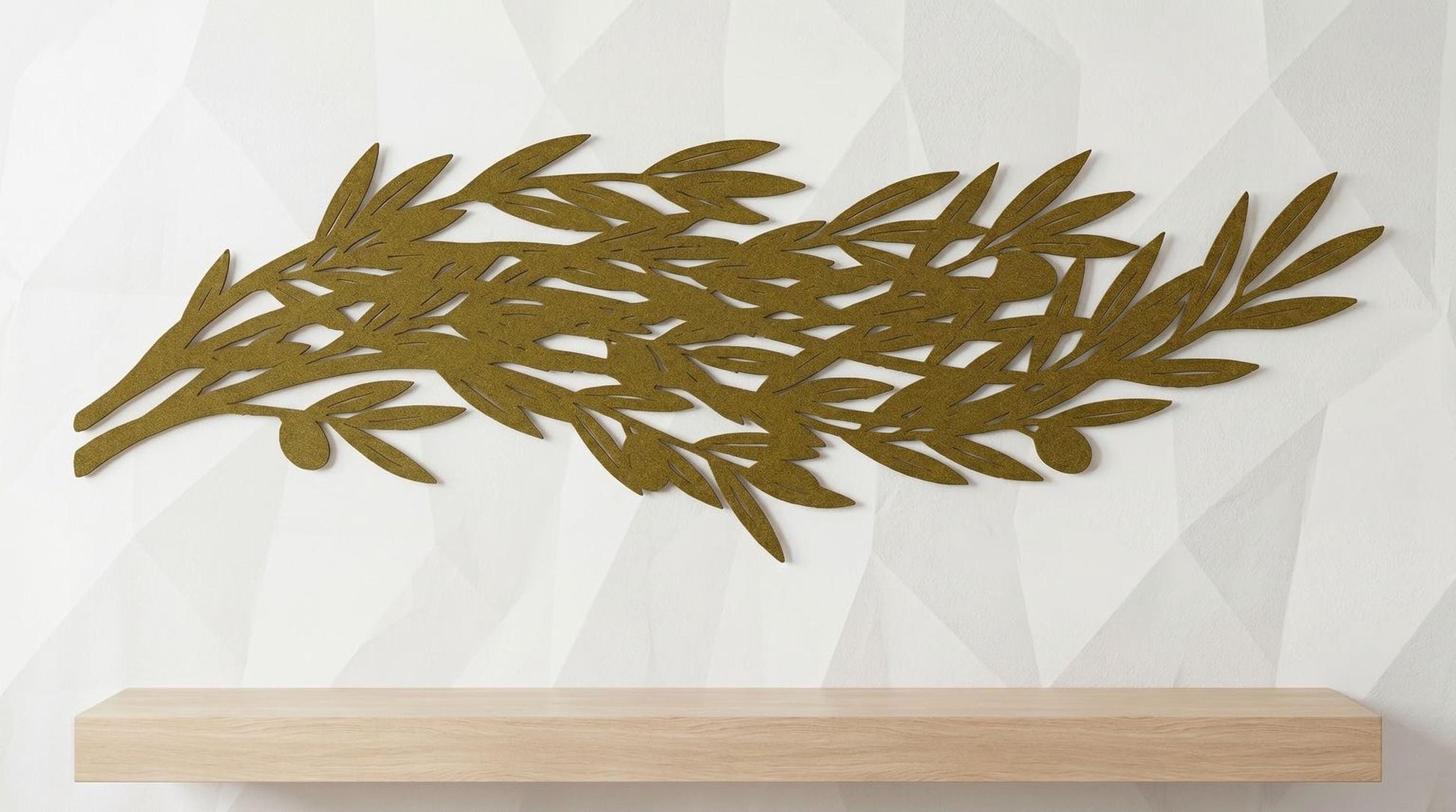 a wooden shelf against a white wall with a decorative gold leaf design on it.