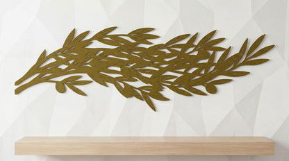 a wooden shelf against a white wall with a decorative gold leaf design on it.