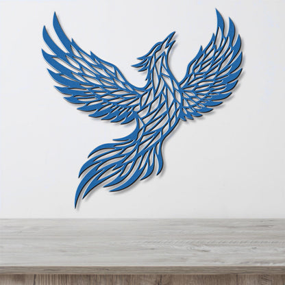 A blue, stylized bird-like figure with outstretched wings is displayed on a white wall above a wooden surface.