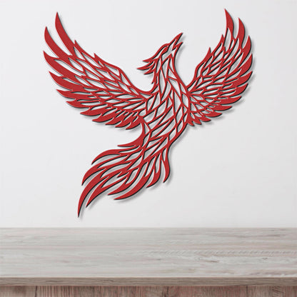 A red, stylized bird-like figure with outstretched wings is displayed on a white wall above a wooden surface.