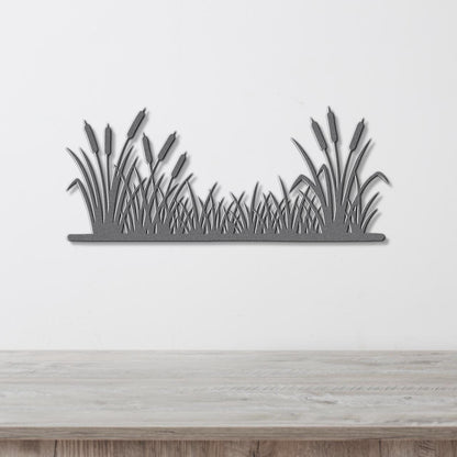 A silhouette of reeds or grasses is displayed on a white wall above a wooden table.