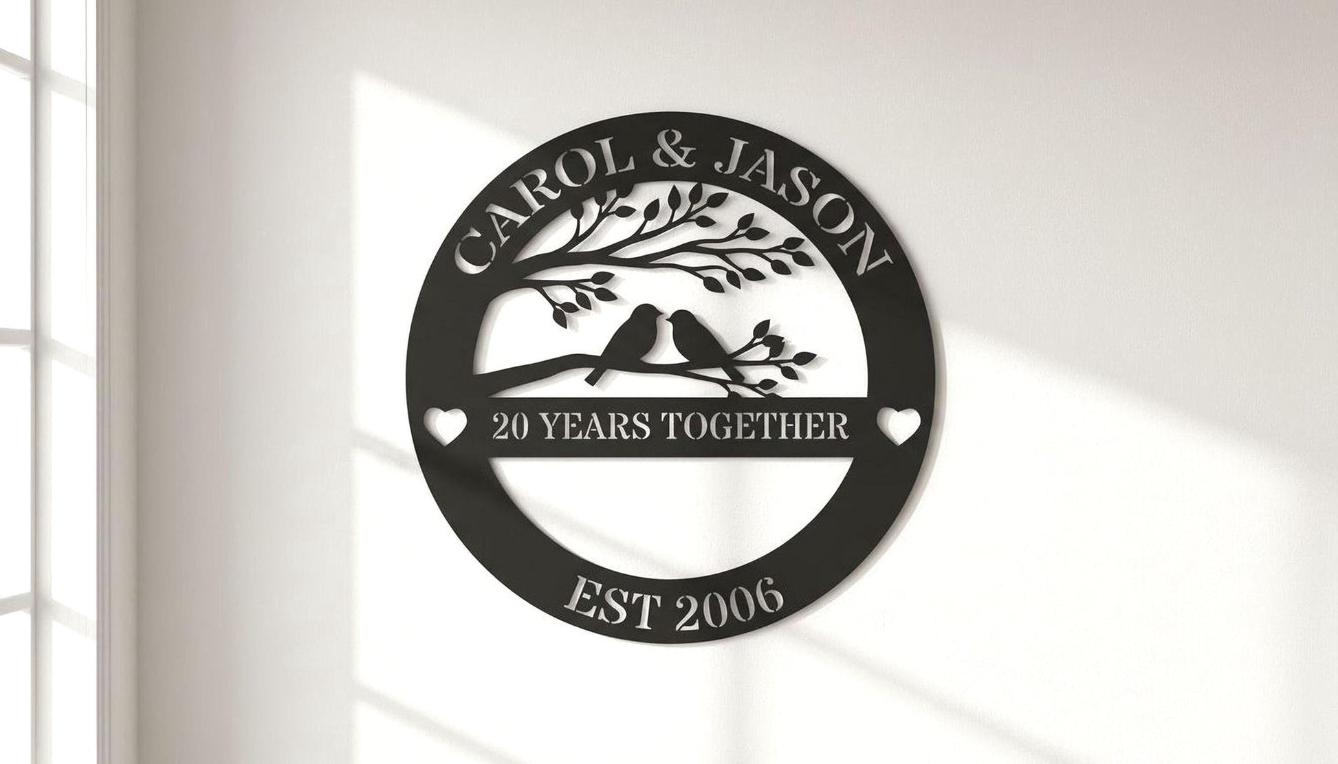 A black and white image of a decorative sign that reads "CAROL & JASON" and "20 YEARS TOGETHER" with a tree and birds on a branch.