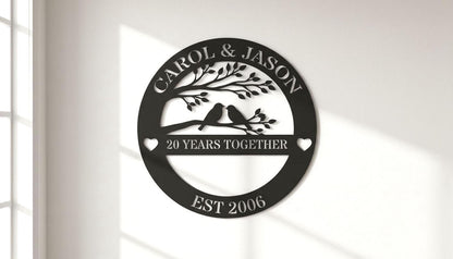 A black and white image of a decorative sign that reads "CAROL & JASON" and "20 YEARS TOGETHER" with a tree and birds on a branch.