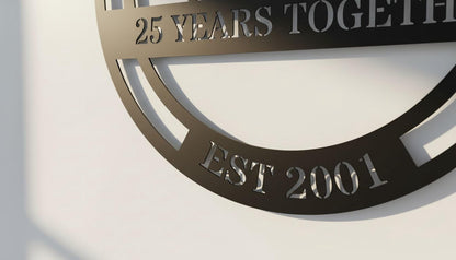 a black metal sign with the text "25 YEARS TOGETHER EST 2001" engraved on it.