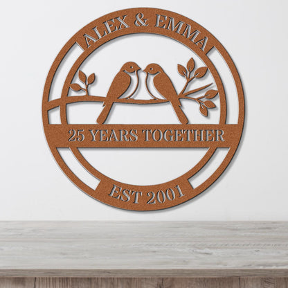 a circular metal sign with the text "Alex & Emma" and "25 YEARS TOGETHER EST 2001" on it.