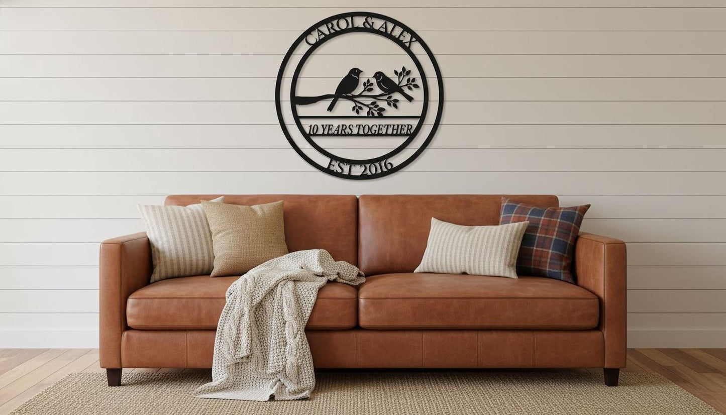 a brown leather couch with two pillows and a blanket, set against a white wall with a decorative metal plaque above it.