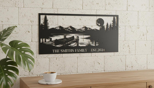 a wall art depicting a serene landscape with a lake, mountains, and a boat, mounted on a wall above a wooden table with a white coffee cup on it.