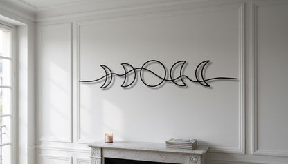 a white fireplace with a decorative metal sculpture of a crescent moon above it. The sculpture is positioned on the wall, creating a visually appealing focal point in the room.