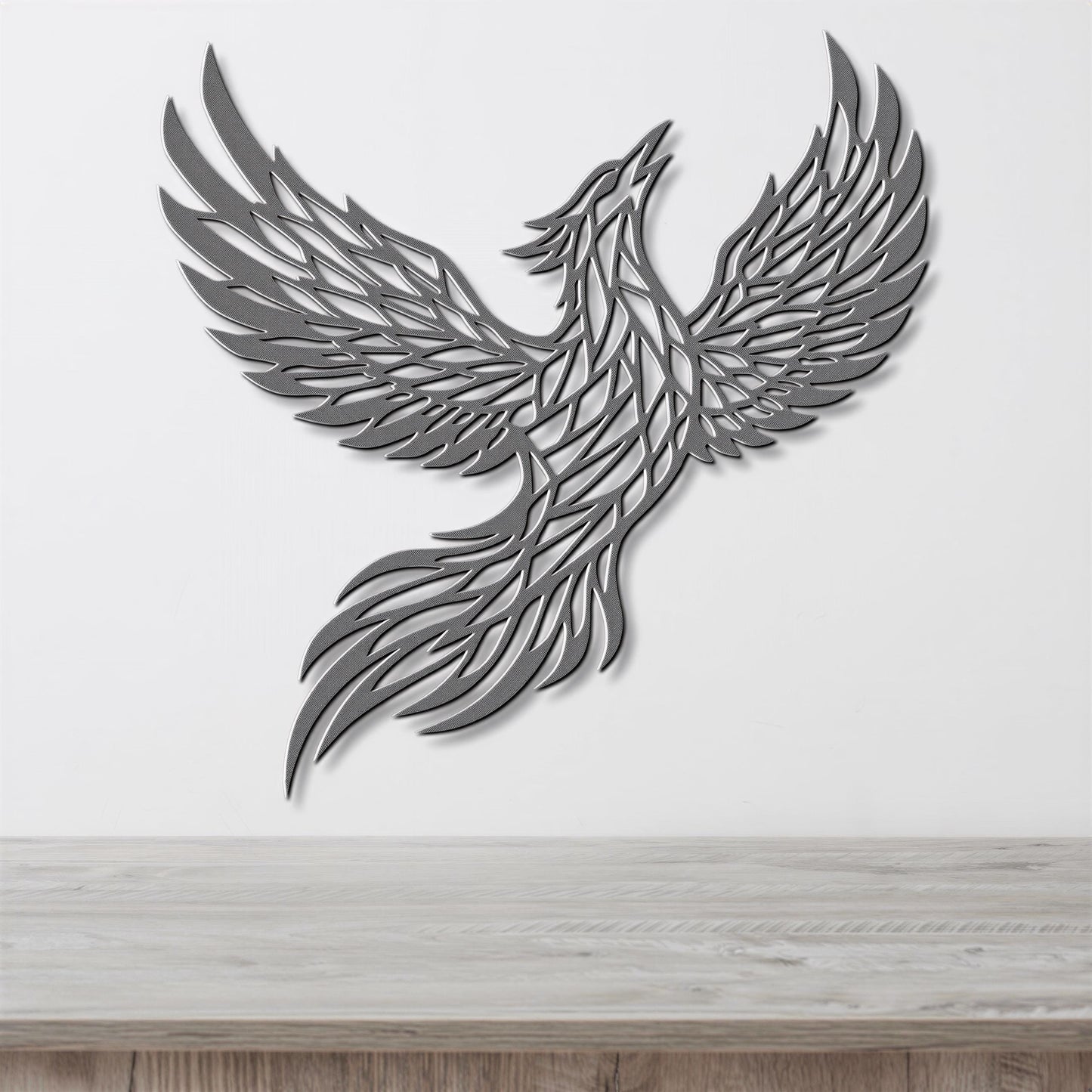 A stylized metal sculpture of a bird in flight, with intricate patterns and designs, mounted on a white wall above a wooden surface.