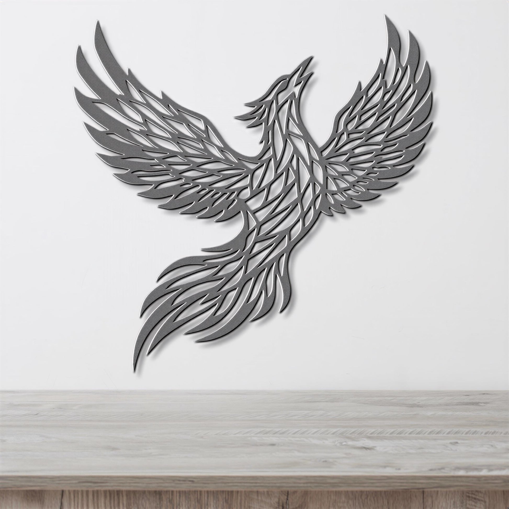 A stylized metal sculpture of a bird in flight, with intricate patterns and designs, mounted on a white wall above a wooden surface.