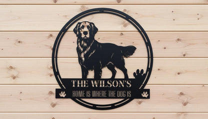 A black and white metal sign featuring a silhouette of a dog and the text "The Wilson's Home is where the dog is"