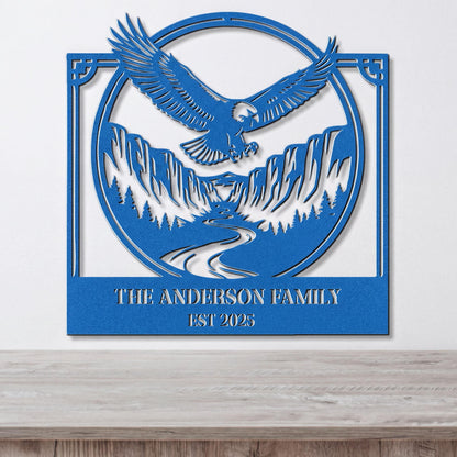 A blue metal wall art piece depicting an eagle in flight above a mountain landscape, with the text "THE ANDERSON FAMILY EST 2025" below the image.