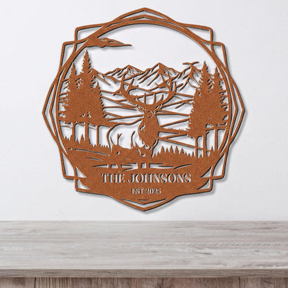 a decorative metal wall hanging depicting a deer in a forest setting with mountains in the background.