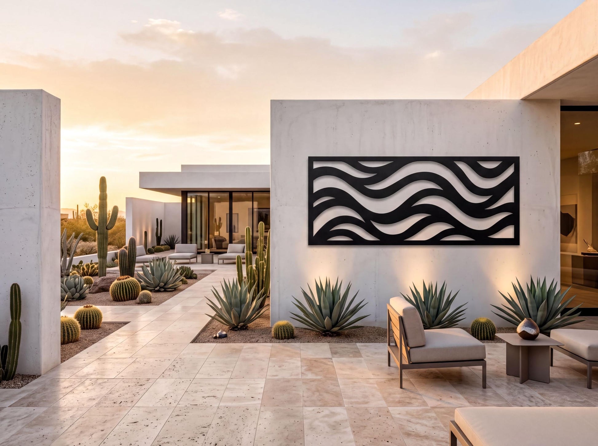 a modern, minimalist outdoor living space with a large, abstract wave-like design on the wall. The space is surrounded by various cacti and succulents, creating a desert-inspired ambiance. The patio area is furnished with comfortable seating, including a sofa and chairs, providing a relaxing environment for outdoor living. The overall design and layout of the space suggest a contemporary and luxurious residential setting.