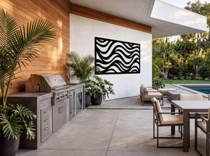 a modern outdoor kitchen with a sleek, contemporary design. The kitchen is equipped with a stainless steel grill and has a large window overlooking a pool and lush greenery. The space is decorated with potted plants and a striking black and white abstract artwork on the wall, creating a visually appealing and inviting atmosphere.