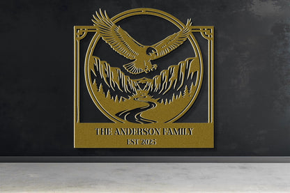 a gold-colored metal plaque with a stylized eagle and mountain landscape design.