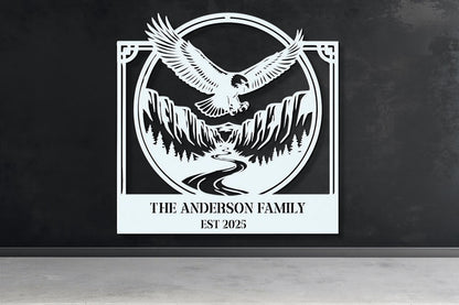 a large white sign with a black eagle and mountains in the background, mounted on a wall.