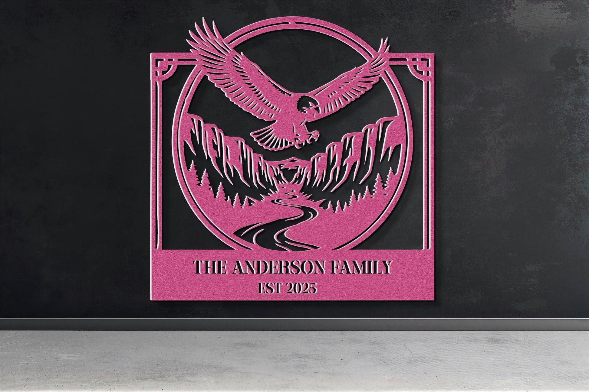 a pink metal sign with a stylized eagle and mountain landscape design.