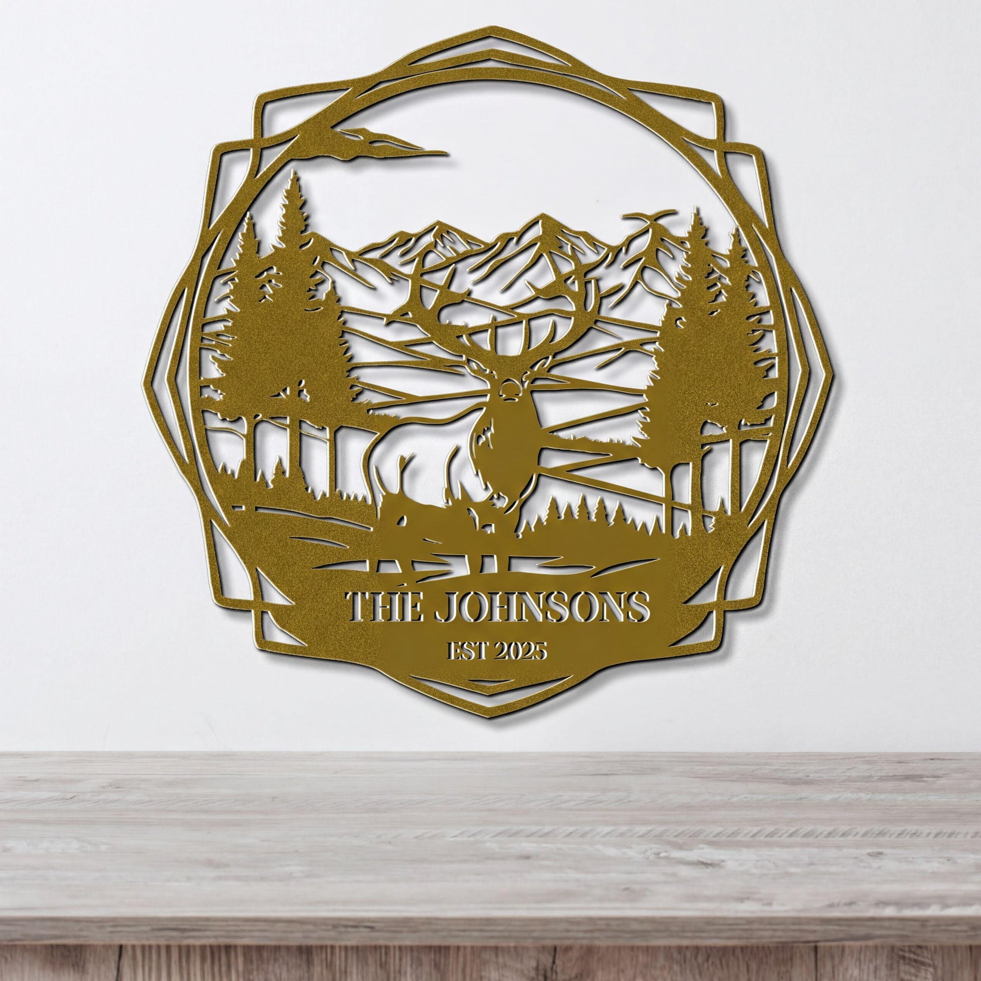 a decorative metal wall hanging depicting a deer in a forest setting with mountains in the background.