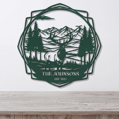 A metal wall art piece depicting a deer in a forest setting with mountains in the background.