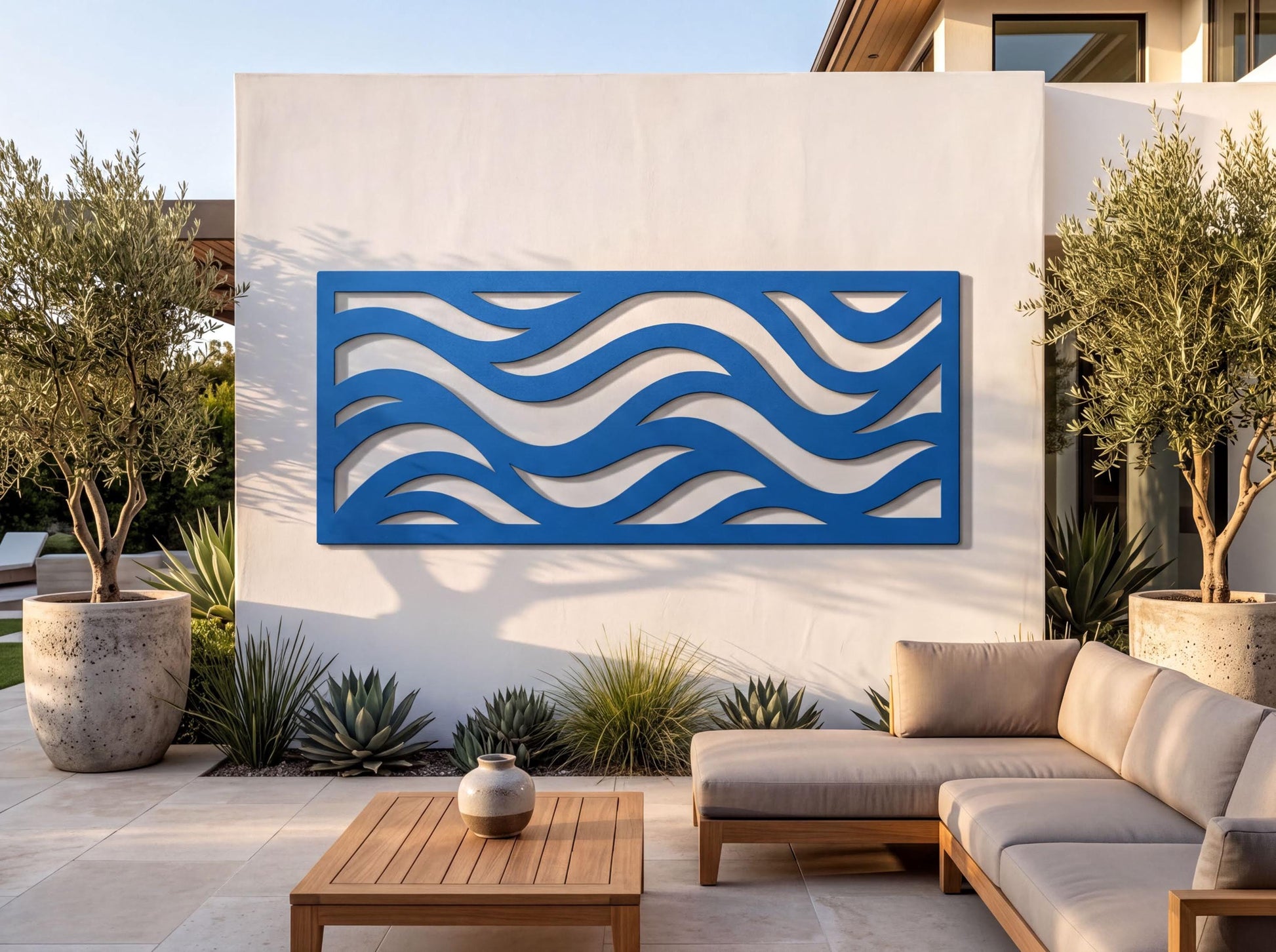 a modern outdoor living space with a large blue wave-shaped wall art piece, a wooden table, and a comfortable sofa.