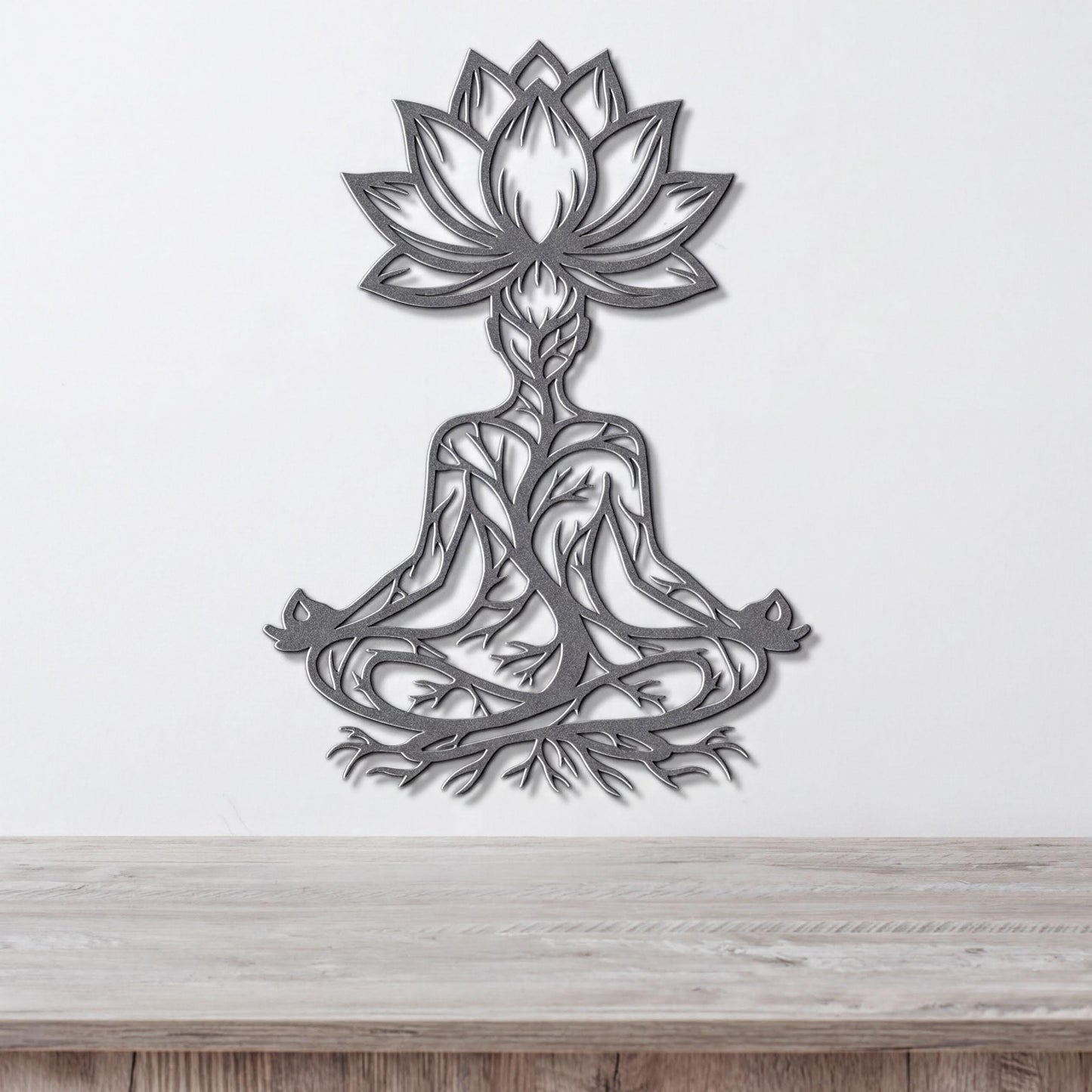 A metal wall art depicting a stylized figure in a meditative pose, with intricate floral and tree-like designs surrounding it.