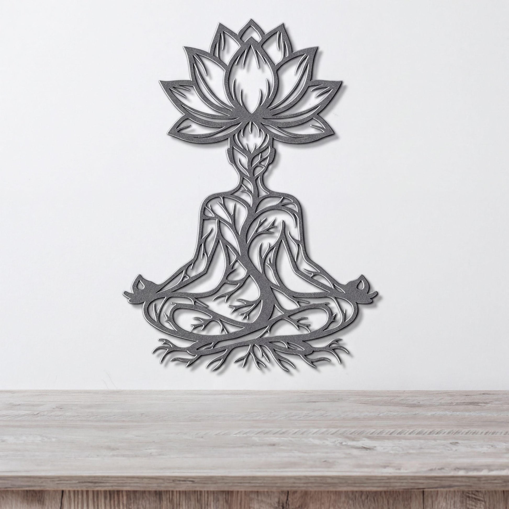 A metal wall art depicting a stylized figure in a meditative pose, with intricate floral and tree-like designs surrounding it.