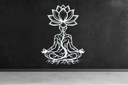 A white silhouette of a person in a meditative pose, with a lotus flower above them, is displayed on a black wall.
