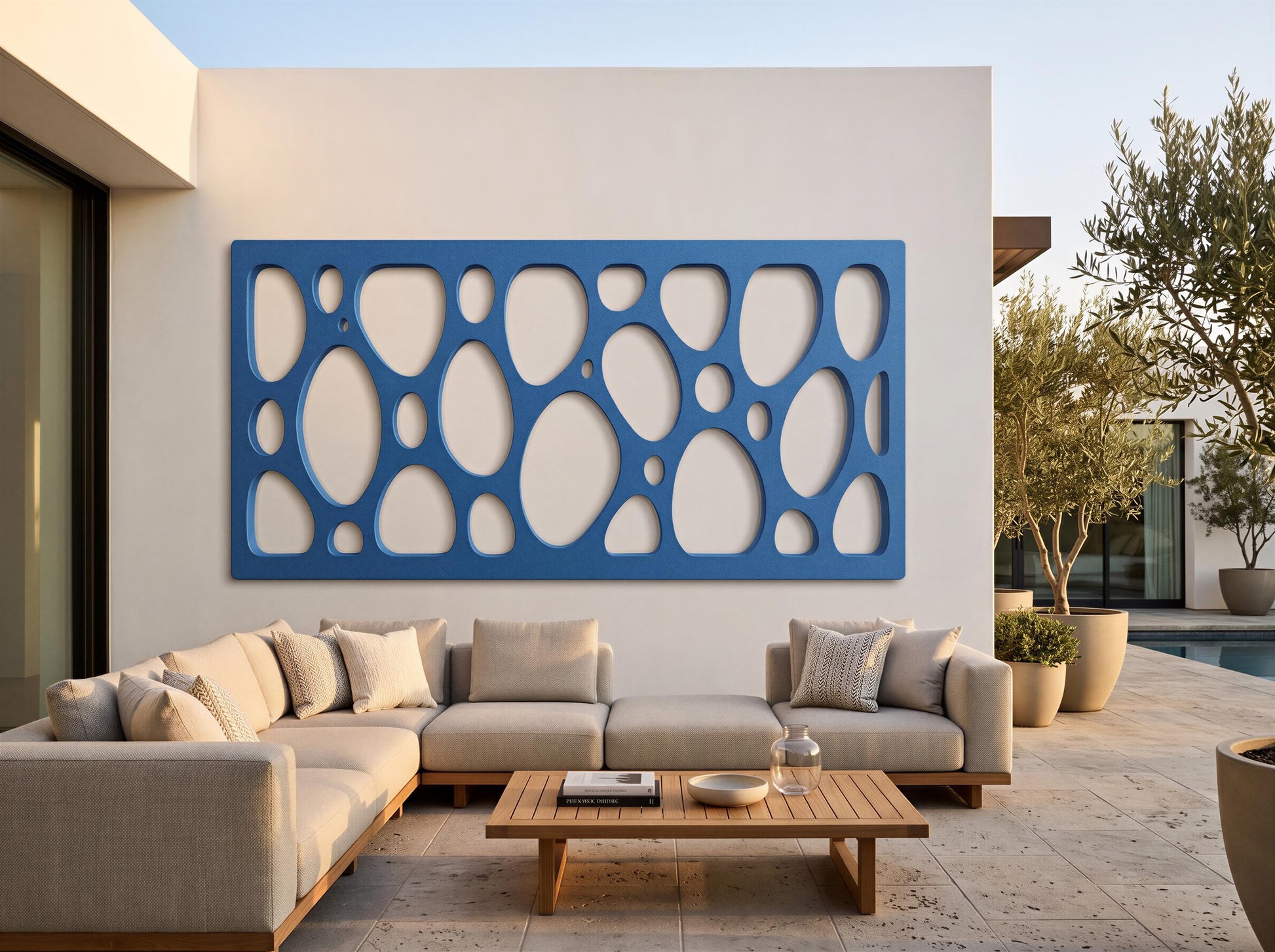 a modern outdoor living space with a large blue wall art piece and a comfortable sectional sofa.