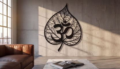 a large leaf-shaped metal sculpture with the Om symbol on it, mounted on a concrete wall in a living room setting.