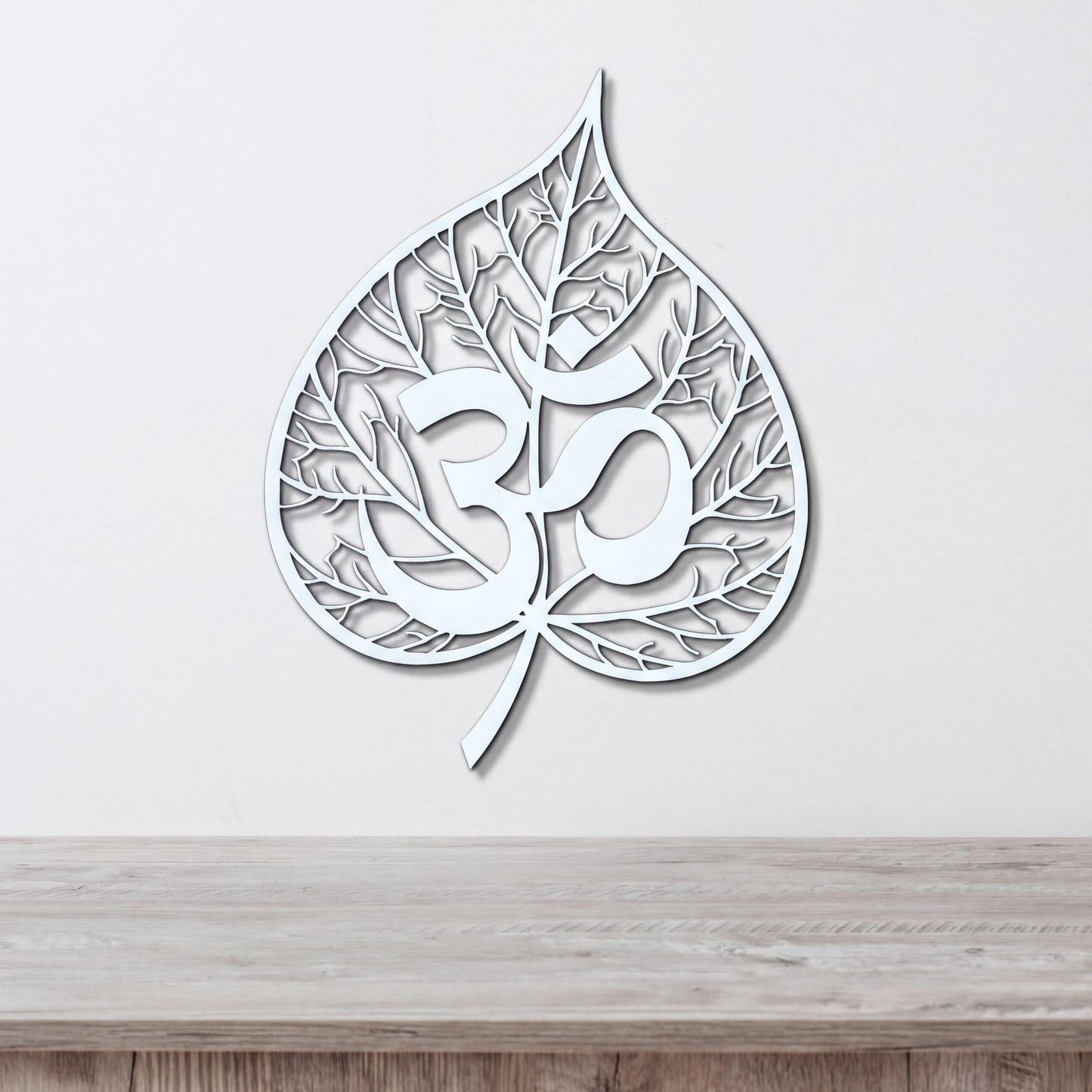 A white leaf-shaped wall art piece with the Om symbol (Om) prominently displayed in the center.
