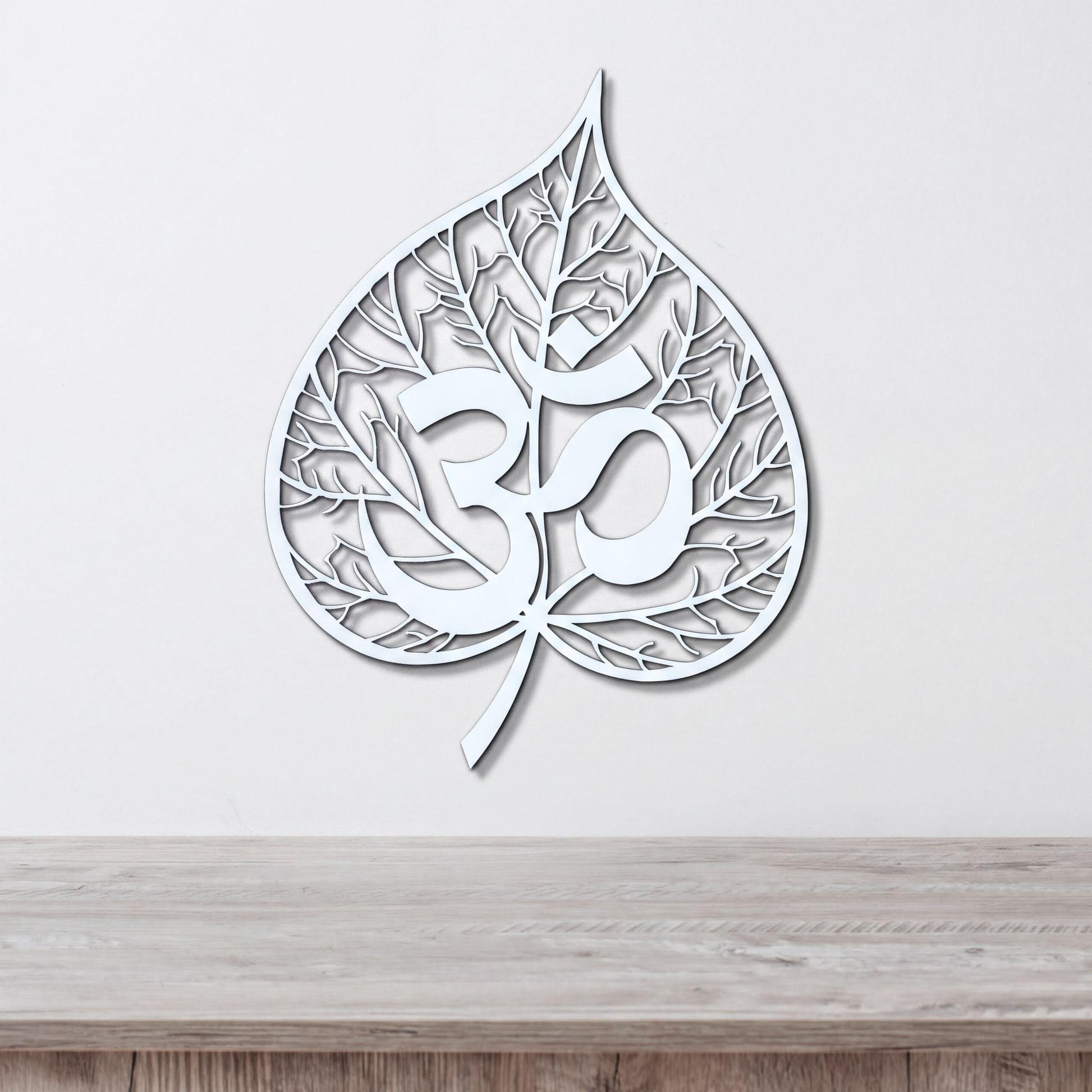 A white leaf-shaped wall art piece with the Om symbol (Om) prominently displayed in the center.