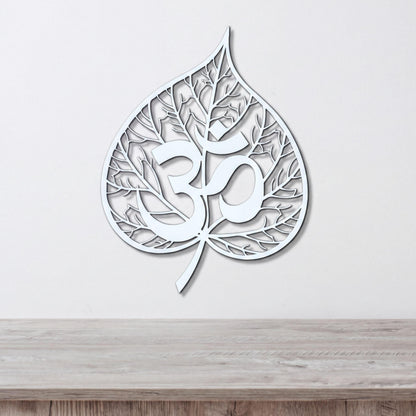 A white leaf-shaped wall art piece with the Om symbol (Om) prominently displayed in the center.
