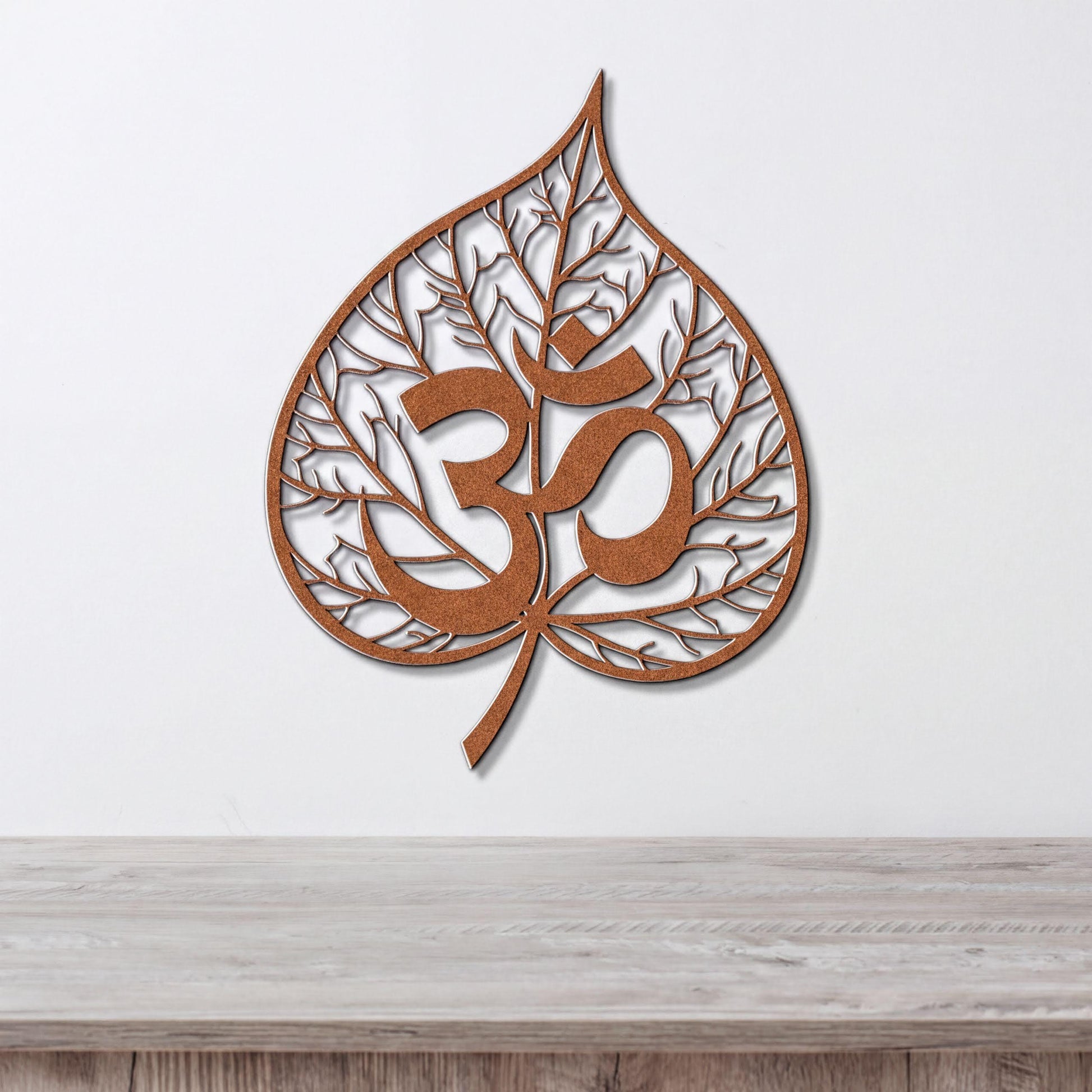 a leaf-shaped wall art piece with the Om symbol (Om) prominently displayed in the center.