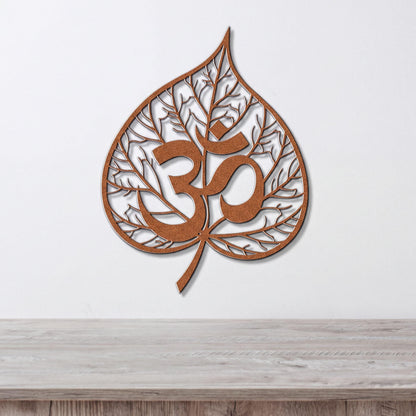 a leaf-shaped wall art piece with the Om symbol (Om) prominently displayed in the center.